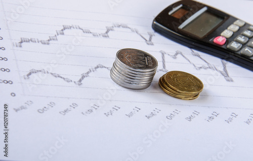 Calculator on the desk pen, calculations, chart, coins