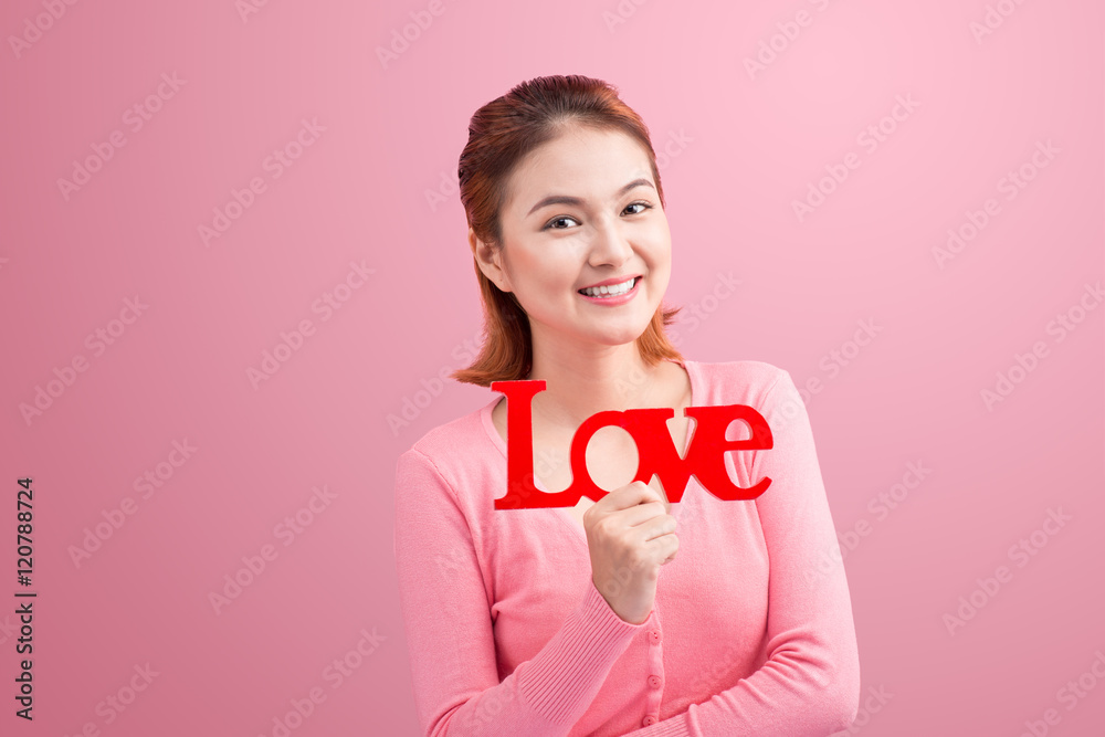 Pretty asian young woman holding wooden letters LOVE on link bac Pretty asian young woman holding wooden letters LOVE on link bac