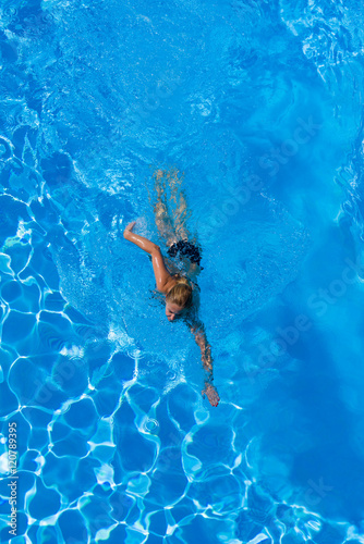 woman with swimsuit swimming on a blue water pool