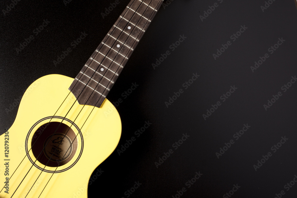 Fototapeta yellow ukulele on black background