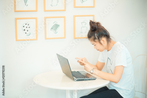 Asian beautiful student woman with laptop and cellphone in cozy