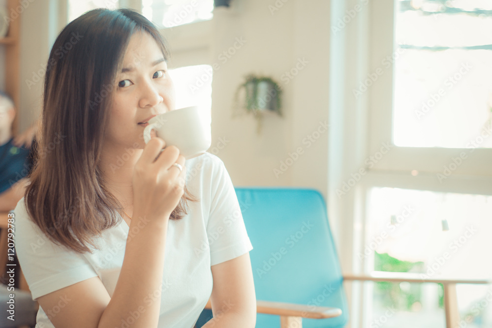 Woman drinking hot latte coffee white cup sitting on sofa cozy r Woman drinking hot latte coffee white cup sitting on sofa cozy r