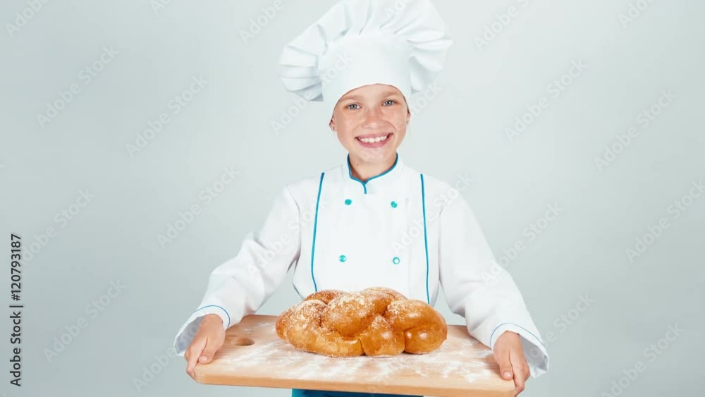Portrait young baker holds cutting board with braided bread and gives loaf you at camera and smiling isolated on white background Portrait young baker holds cutting board with braided bread and gives loaf you at camera and smiling isolated on white background