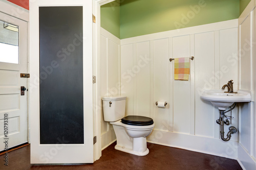 Classic bathroom interior with toilet and sink. Also green and white walls.