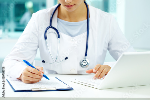 Photography Physician making notes in doctor office