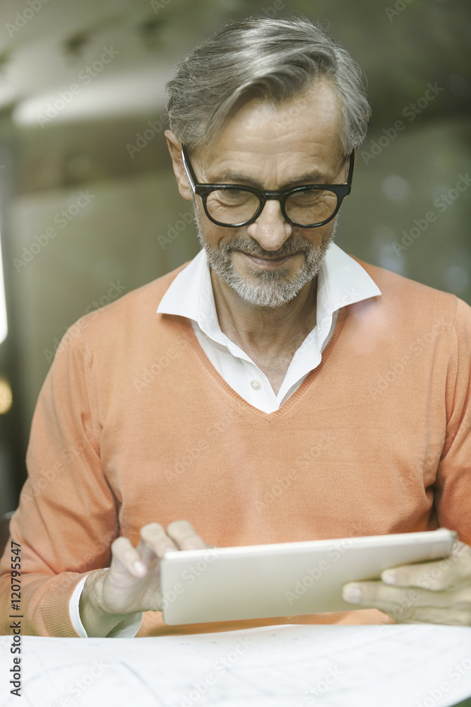 Man with construction plan using tablet Man with construction plan using tablet