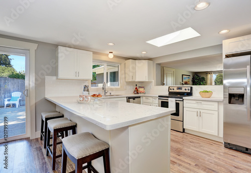 Modern kitchen room interior in white tones with hardwood floor.
