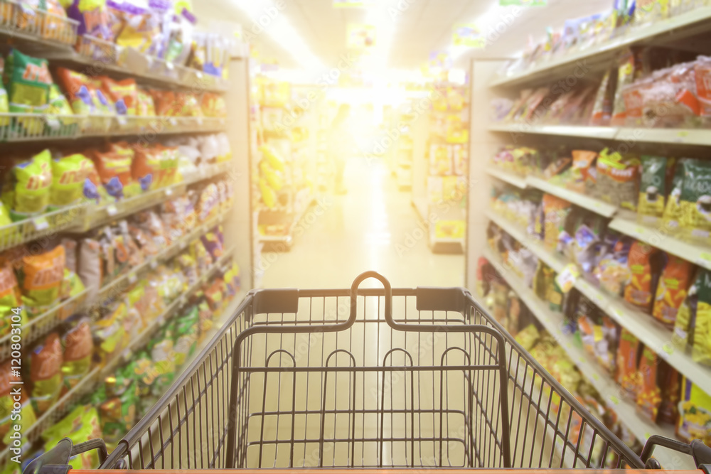 Supermarket aisle sale with empty red shopping cart with customer defocus background