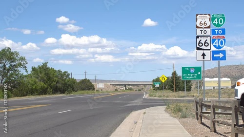 Road signs on route 66, road traffic only on the narrow part of the road in the distance near horizon photo