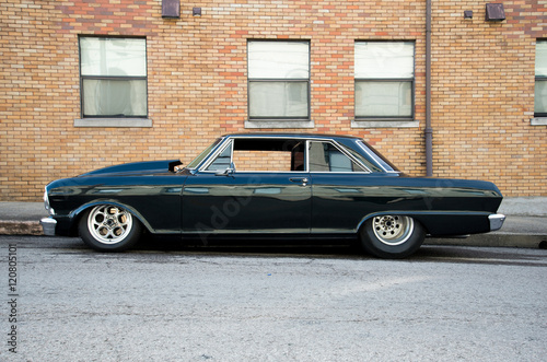 A black classic car parked on a curb. © jctabb