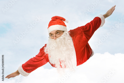 Photo of santa claus flying on the background of sky