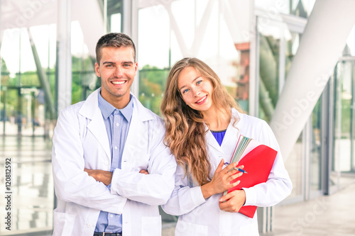 Young doctor and nurse assistant - Medical students or dentists with white coat smiling at camera 