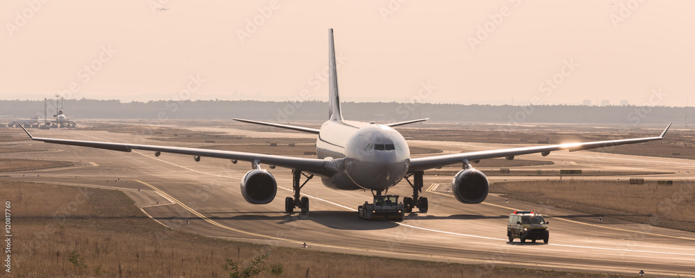 Obraz premium airplane beeing towed on a runway
