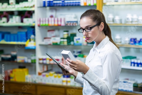 Free Download Pharmacist using digital tablet while checking medicine - GFXLoad