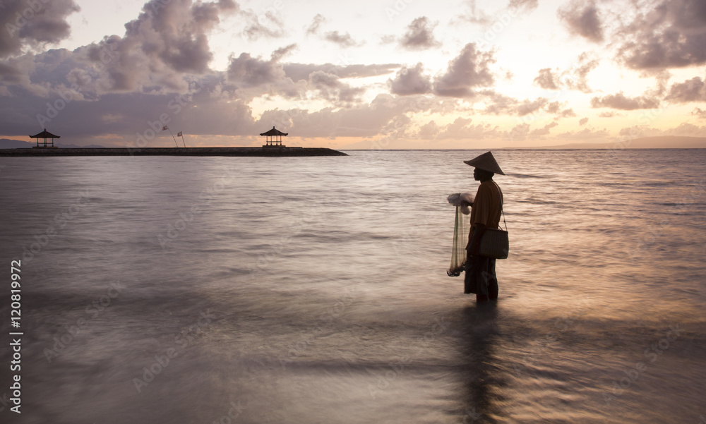 silhouette of a fisherman of Bali throwing a net silhouette of a fisherman of Bali throwing a net