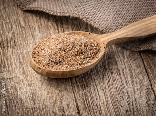 Wheat bran in wooden spoon