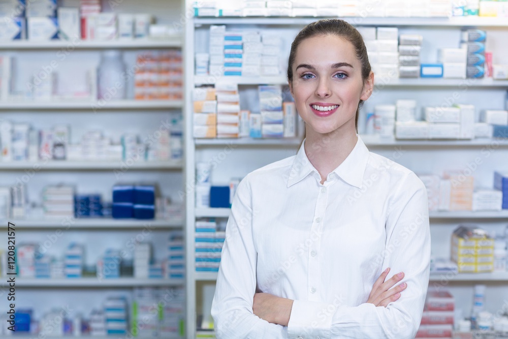 Pharmacist standing with arms crossed in pharmacy Pharmacist standing with arms crossed in pharmacy