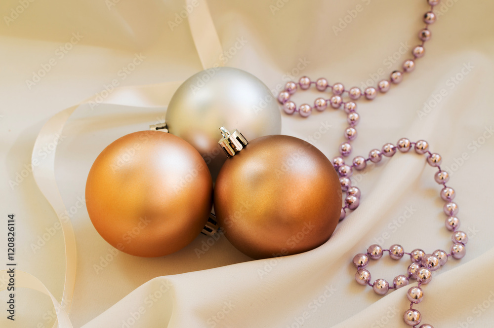 Some golden christmas balls on the white fabric Some golden christmas balls on the white fabric