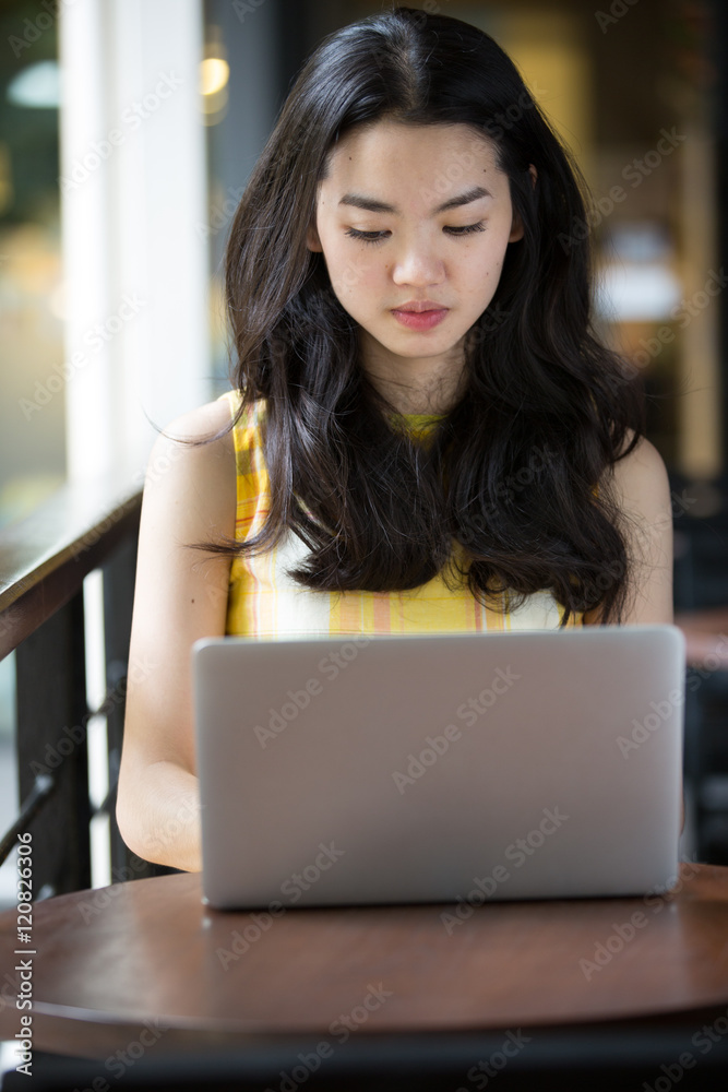 Asian woman happily using a notebook