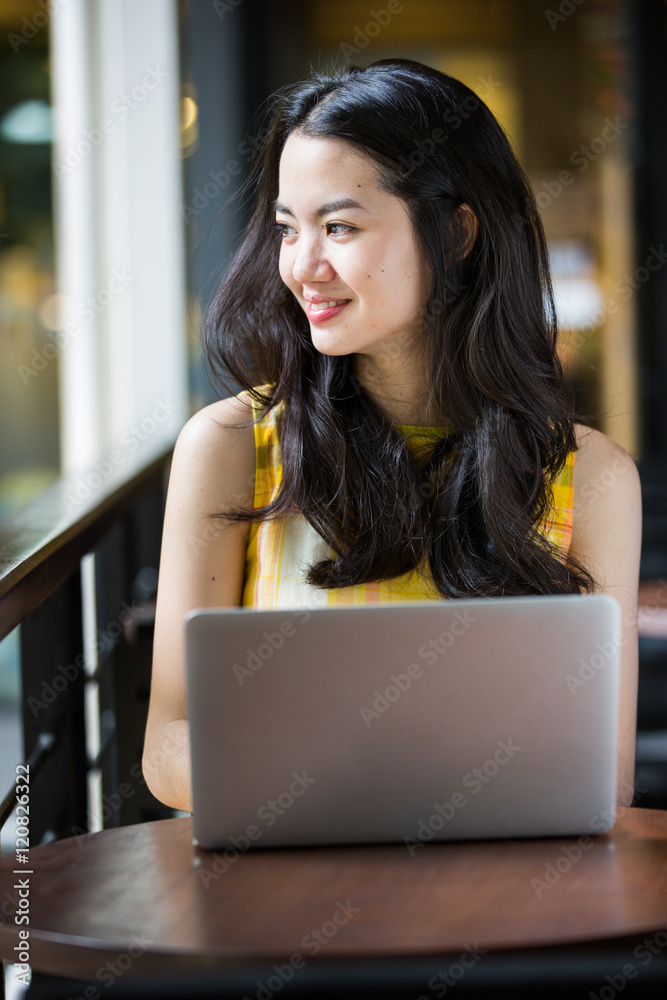 © Lodimup - Asian woman happily using a notebook