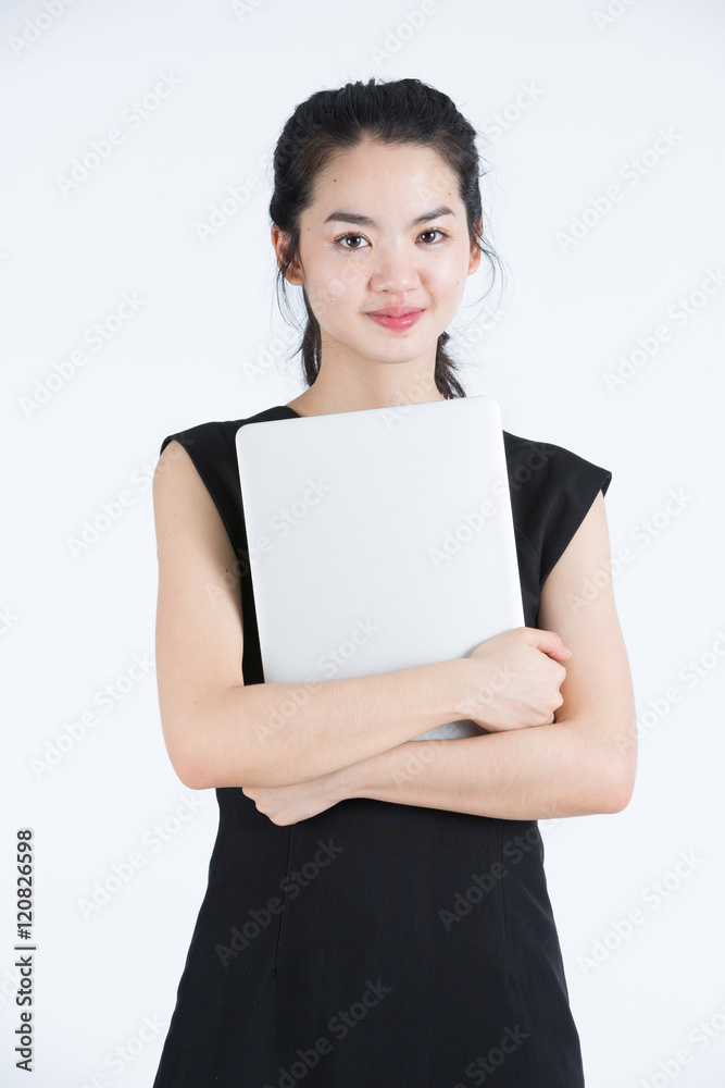 Asian business woman holding a laptop, standing Asian business woman holding a laptop, standing