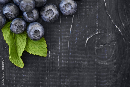 fresh berries and mint on rustic dark wooden background