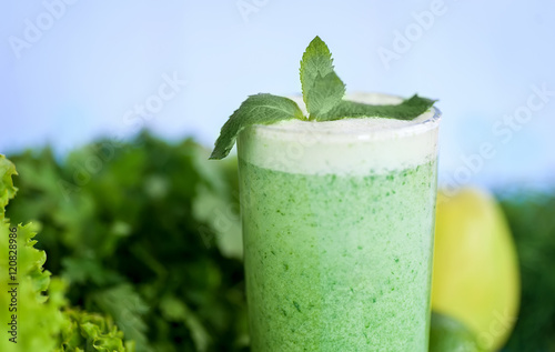 Detox diet, healthy food concept. green smoothie in glass, fruits and vegetables on blue wooden desk