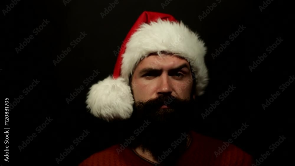 emotional bearded young man in the hat of Santa Claus moves his eyebrows emotional bearded young man in the hat of Santa Claus moves his eyebrows