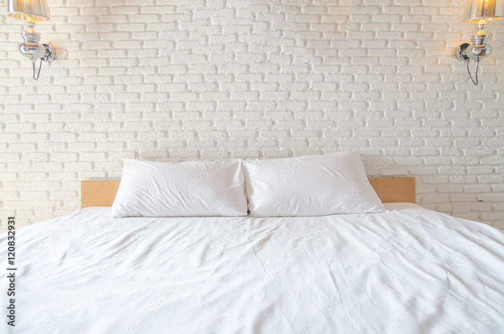 white Pillow on white bed with brickwall background