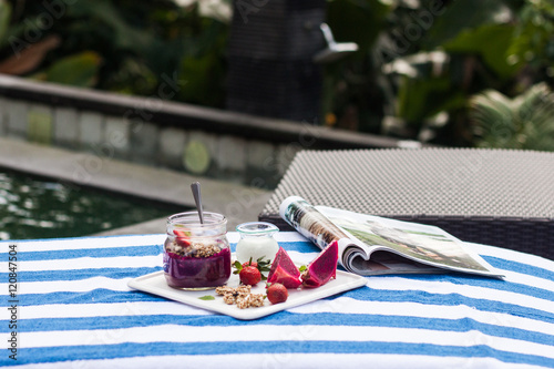 Foto Healthy breakfast, smoothie with  granola and yogurt near the pool