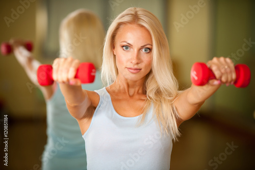Fitness workout - fit woman training with dumbellc in gym