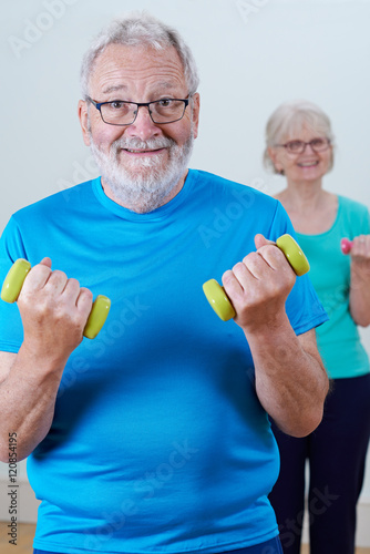 Senior Couple In Fitness Class Using Weights