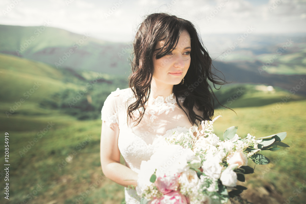 Beauty woman, bride with perfect white dress posing on the rock background mountains Beauty woman, bride with perfect white dress posing on the rock background mountains