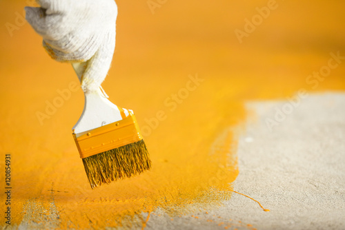 Hand with brush and yellow paint photo