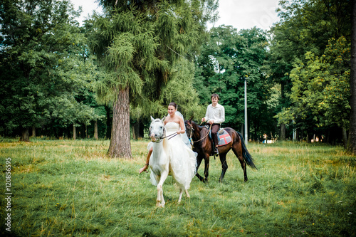 happy bride and groom on horseback in the forest, beautiful nature