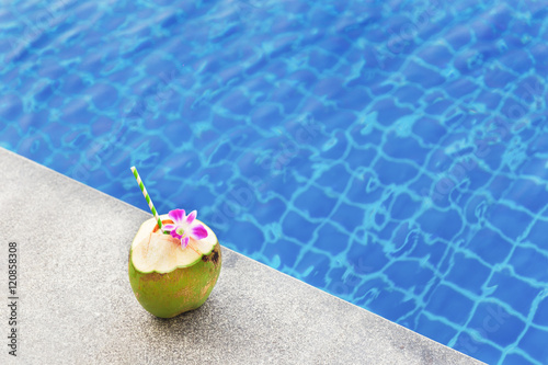 Coconut juice with orchid flower on swimming pool