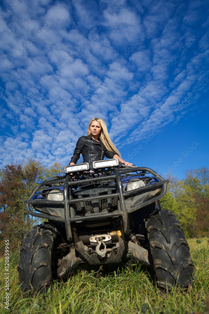 Fototapeta premium Elegant blonde woman riding extreme quadrocycle ATV on summer fi