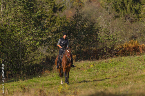 Elegant attractive woman riding a horse