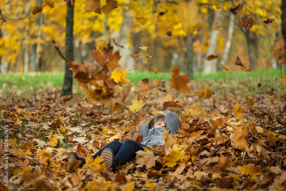Young girl throwing leaves in autumn park Young girl throwing leaves in autumn park