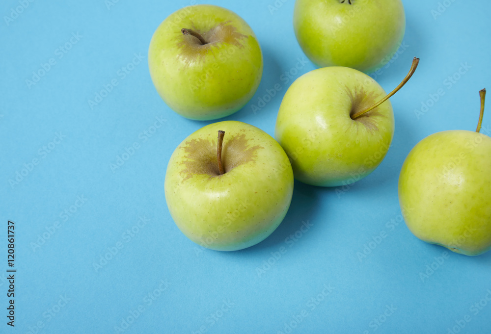 Green apples on a bright blue background forming a page border Green apples on a bright blue background forming a page border