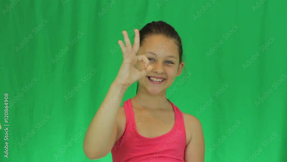athlete smiling girl showing gesture that everything's okay on a green background athlete smiling girl showing gesture that everything's okay on a green background