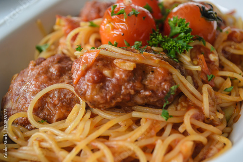 Spaghetti with meatballs in tomato marinara sauce and indegredient on plate