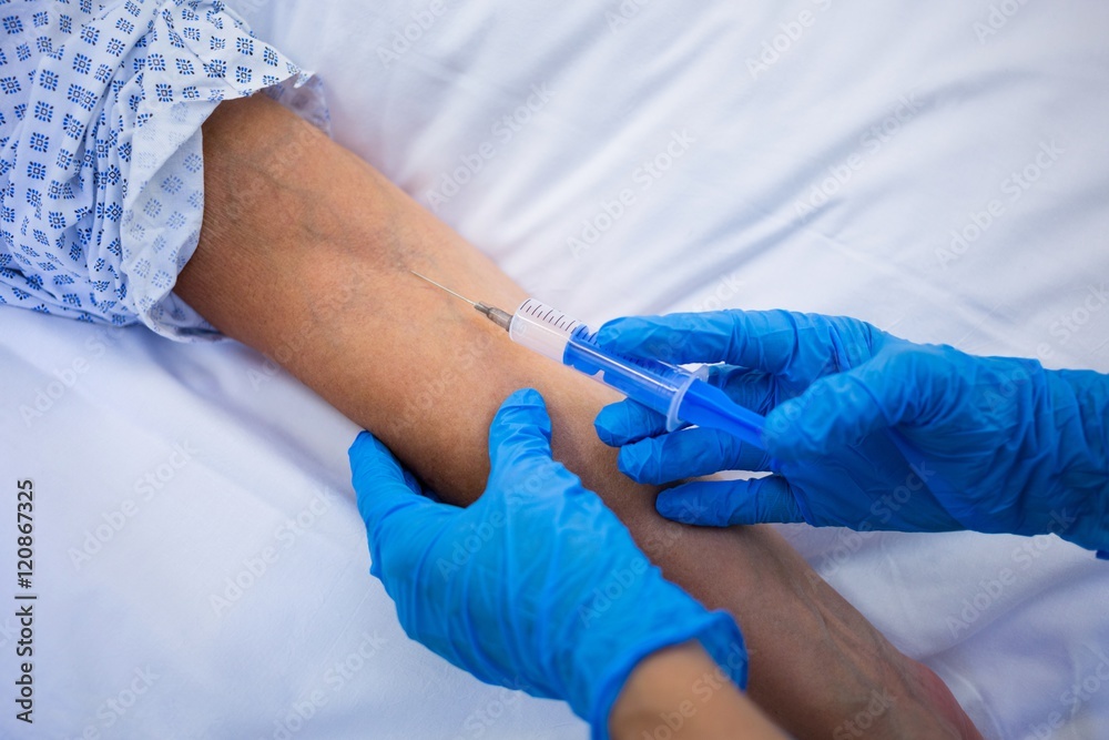 Nurse giving an injection to a patient Nurse giving an injection to a patient