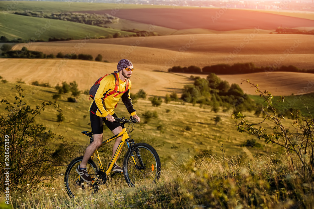 Fototapeta premium Young man cycling on a rural road