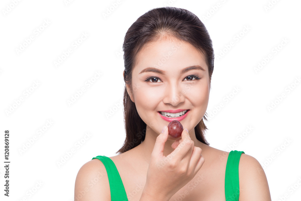 Young beautiful asian woman eating fresh grapes isolated on whit Young beautiful asian woman eating fresh grapes isolated on whit
