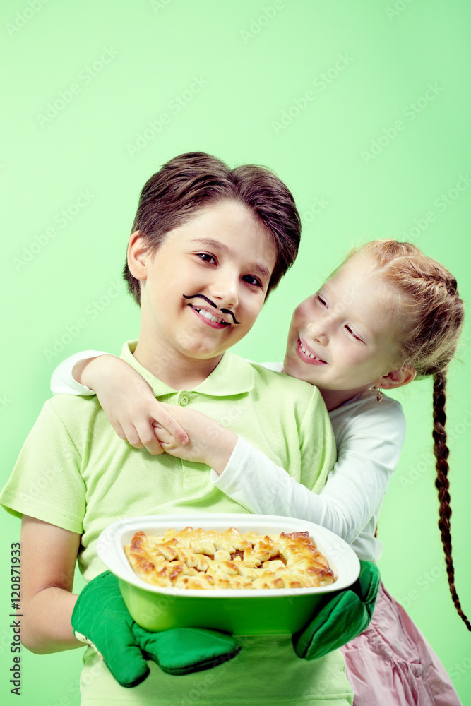 Portrait of little boy with apple pie embracing his girlfriend Portrait of little boy with apple pie embracing his girlfriend