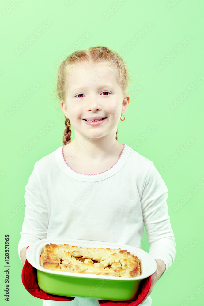 Portrait of little girl with apple pie looking at camera and smiling Portrait of little girl with apple pie looking at camera and smiling