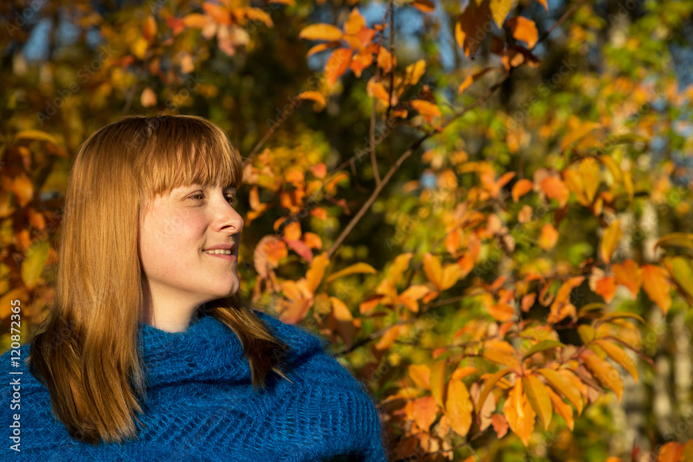 eine Frau mit blauem Schal vor herbstlichem Hintergrund eine Frau mit blauem Schal vor herbstlichem Hintergrund