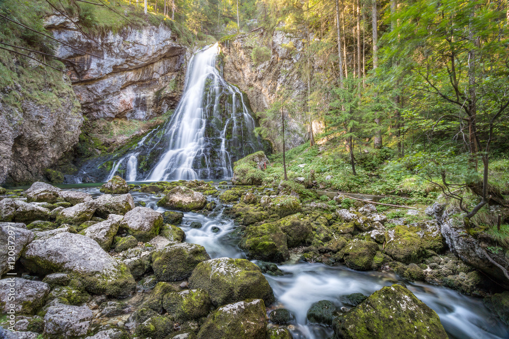 Fototapeta premium Waterfall with stream in idyllic forest