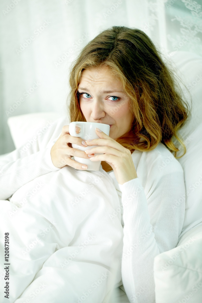 Unhappy woman lying in bed and taking her medicine Unhappy woman lying in bed and taking her medicine
